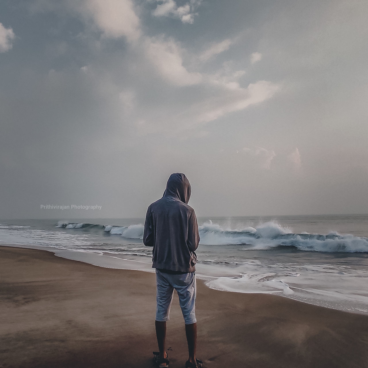 sea, ocean, beach, water, horizon, land, sky, coast, rear view, wave, cloud, shore, full length, body of water, one person, beauty in nature, horizon over water, nature, standing, sand, holiday, vacation, adult, trip, scenics - nature, casual clothing, men, leisure activity, wind wave, motion, solitude, lifestyles, tranquility, looking at view, outdoors, wind, contemplation, morning, relaxation, day, young adult, looking, environment, overcast, child, clothing, travel destinations, hood