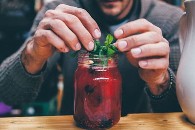 Mid section of a man preparing drink