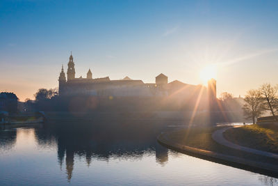 Buildings at waterfront during sunset