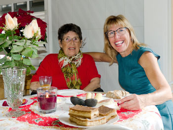 Portrait of cheerful friends sitting in restaurant