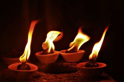 Close-up of diyas burning in temple