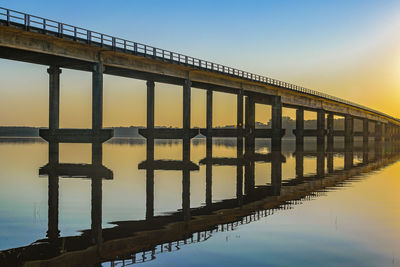 Pier over sea against clear sky during sunset