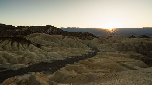 Scenic view of desert against clear sky during sunset