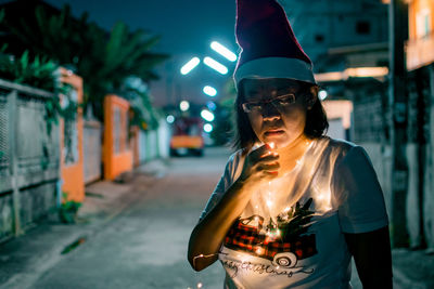 Portrait of young woman standing on street