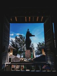 Low angle view of statue against buildings