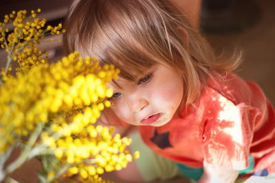 Close-up of cute baby girl looking away by plants