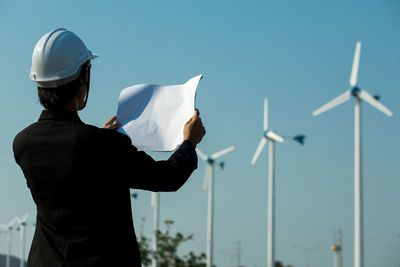 Man holding umbrella against sky
