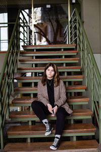 Portrait of young woman sitting on staircase