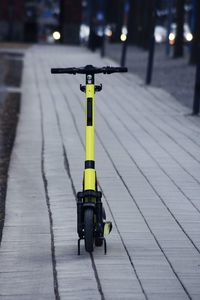 Rear view of man riding push scooter on street