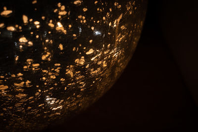 Close-up of illuminated lamp against black background