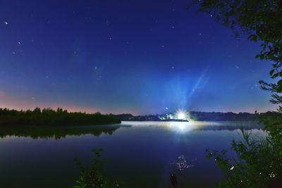 Scenic view of lake against sky at night