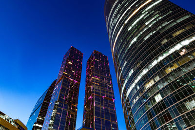 Low angle view of illuminated buildings against blue sky