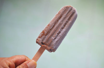 Close-up of hand holding ice cream stick