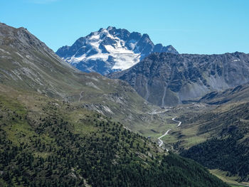 Scenic view of snowcapped mountains against blue sky