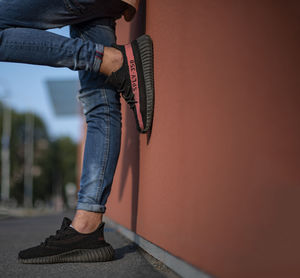 Low section of man standing against wall