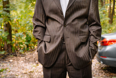 Midsection of man with business suit standing outdoors