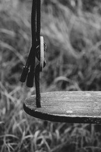 Close-up of rusty metal hanging on wood at field