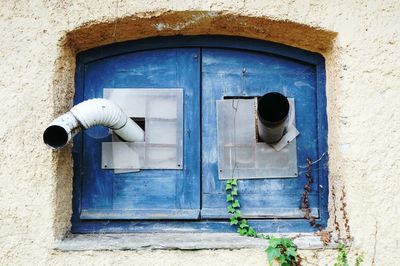 Pipes on window amidst wall