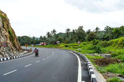 Road amidst trees against sky