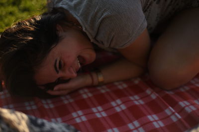 Smiling woman lying on picnic blanket