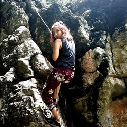 Young woman standing on rock by river