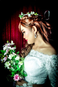 Portrait of a beautiful young woman with red flower