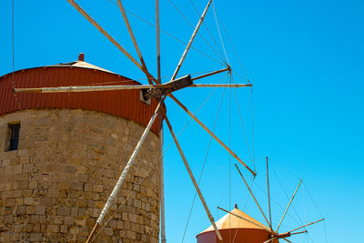 Low angle view of traditional windmill against clear blue sky