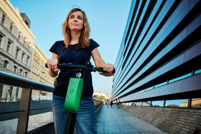 Woman rides on rental electric scooter at city