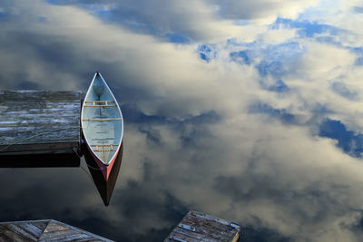 Canoe floating on the cloud reflections