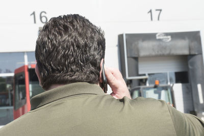 Rear view of man using mobile phone