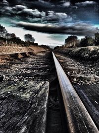 Railroad track against cloudy sky