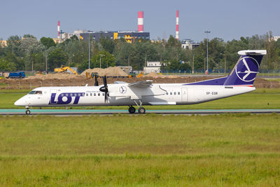 Side view of airplane on runway against sky