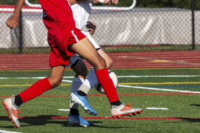 Low section of soccer players playing at field