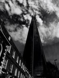 Low angle view of modern building against cloudy sky