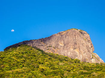 Low angle view of rocks against blue sky