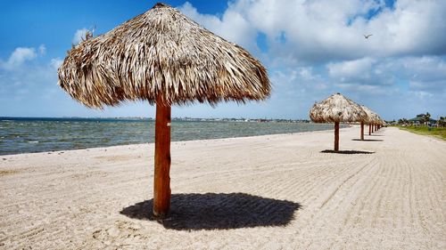 Umbrellas on beach against sky