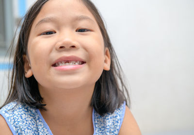 Asian kid girl smile and showing her broken milk teeth.