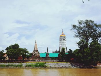 Tower of building by river against sky