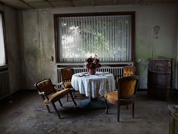 Empty chairs and table in abandoned room at home