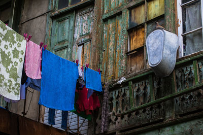 Low angle view of clothesline hanging against abandoned house