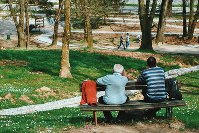 Friends sitting on bench in park