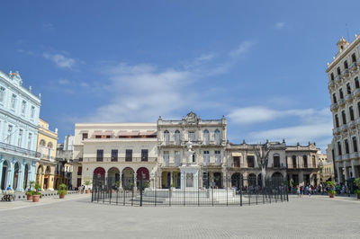 Buildings in town against cloudy sky