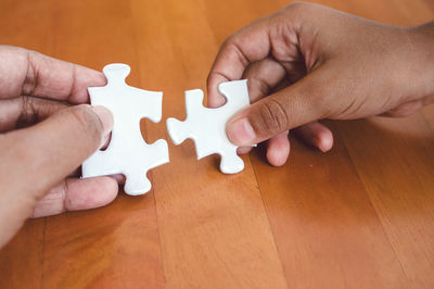 Close-up of hands playing jigsaw puzzle