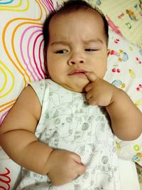 Baby girl lying on bed