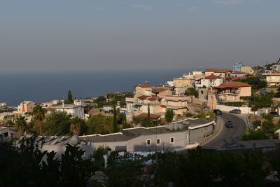 High angle view of townscape by sea against sky