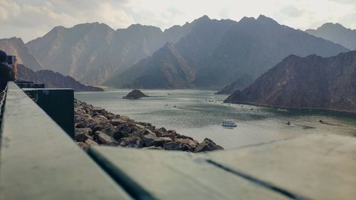 Scenic view of sea by mountains against sky