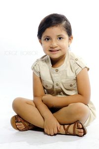 Portrait of young woman sitting on wall