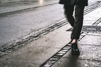 Low section of man standing on road