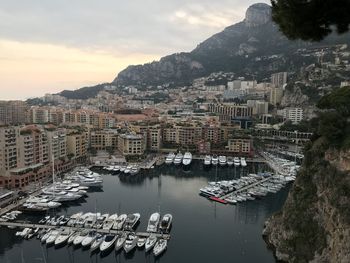 High angle view of boats moored in sea against buildings in city