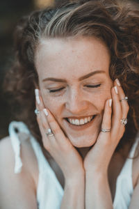 Close-up of smiling young woman with eyes closed